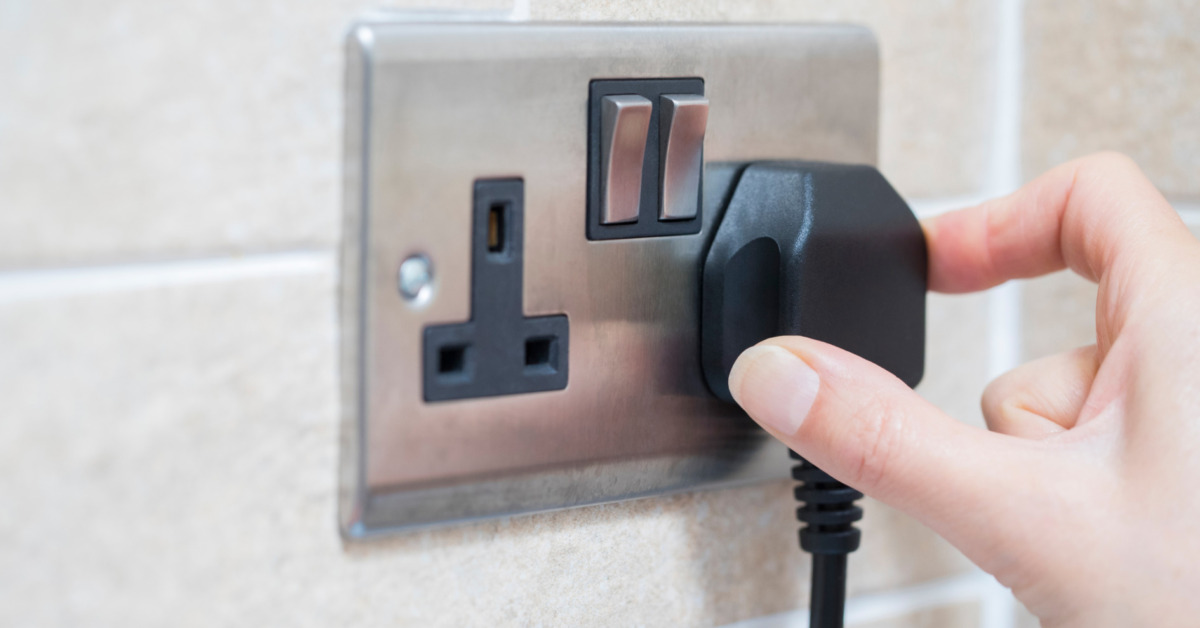 Hand Putting Plug Into Electricity Socket