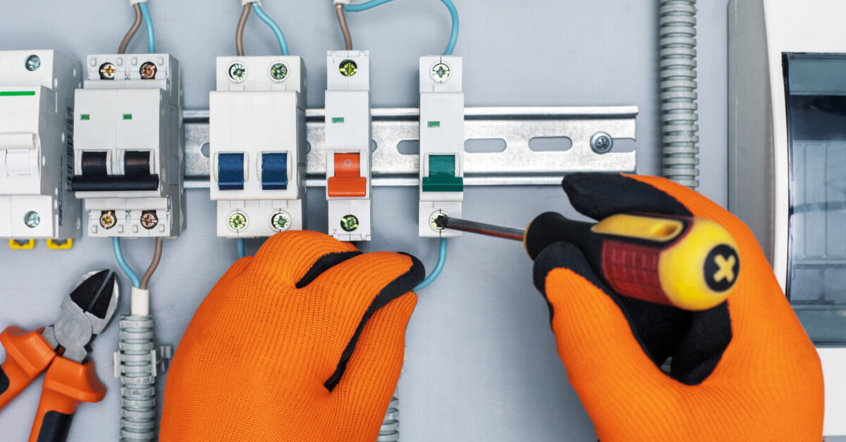 Electrician Repairing Electrical Box With Screwdriver And Pliers