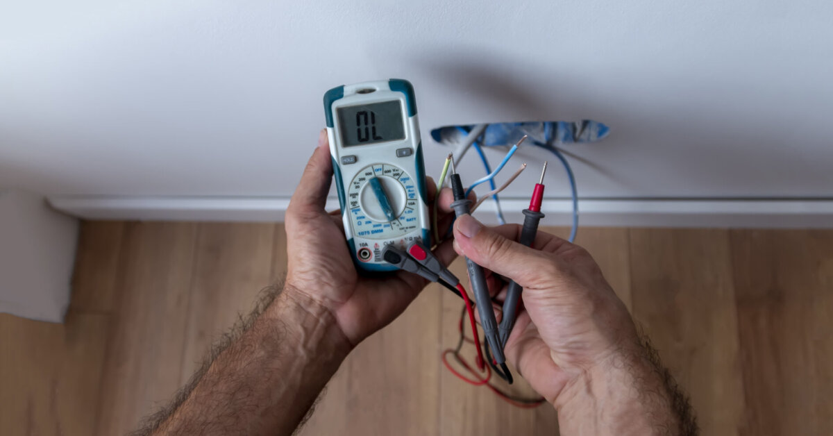 Electrician Is Using A Digital Meter To Measure The Voltage At The Power Outlet